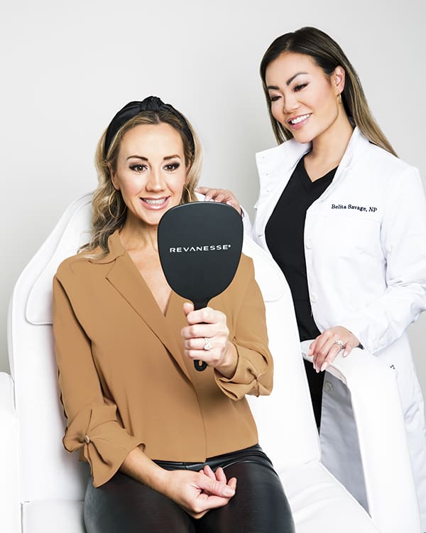belita savage with a patient holding a mirror looking at her face after receiving botox and lip filler near me